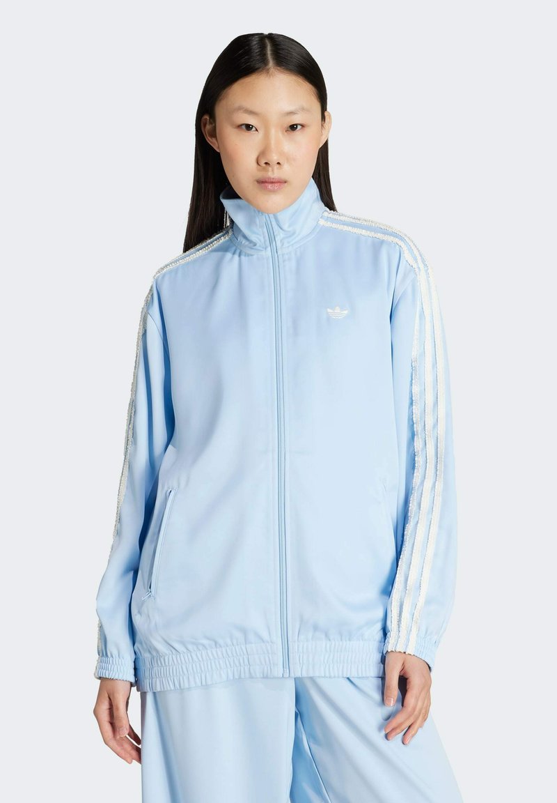 Svetlomodrá športová bunda s vysokým golierom, zipsom a bielymi pruhmi na rukávoch. Vyrobená z hladkej, ľahkej tkaniny.
