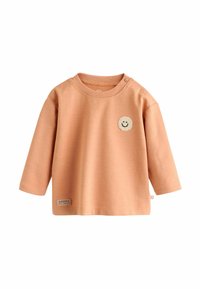 Világos őszibarack színű, hosszú ujjú ing puha anyagból, kerek nyakkivágással. Az alján mosolygó oroszlán folt és "HAPPY" felirat található.