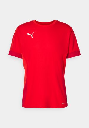 Camiseta atlética roja con cuello redondo, mangas cortas y un ribete contrastante en rojo oscuro. Presenta un logotipo blanco de Puma en el pecho.