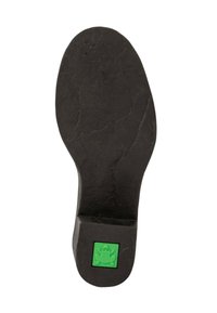 Suela de zapato de goma negra con superficie texturizada. Presenta un logo de rana verde en el talón. Forma redonda con sección del talón elevada.