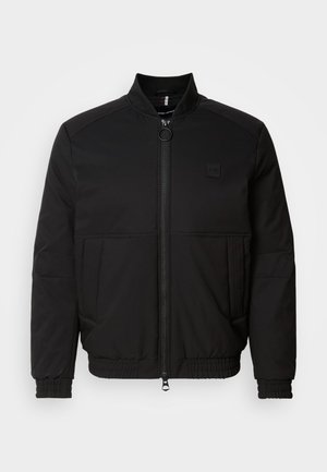 Black bomber jacket with a zip front, stand collar, and elastic cuffs. Features side pockets and a small logo patch on the chest.