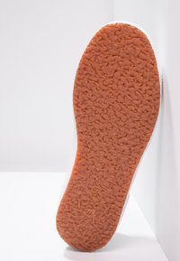 Guma podeszwowa z pomarańczową, teksturowaną powierzchnią i białymi bokami. Posiada wzór zapewniający przyczepność. Czysty i minimalistyczny design.