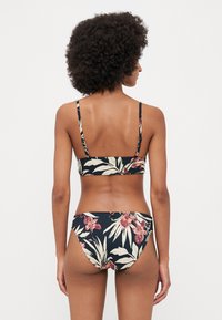 Bikini set in a dark floral pattern, featuring thin straps, a straight-across back top, and low-rise bottoms with a moderate leg cut.