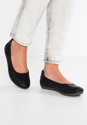 Sorte balletflade med struktureret overflade, rund tå og fleksibel gummisål. Sammen med lysegrå jeans for kontrast.