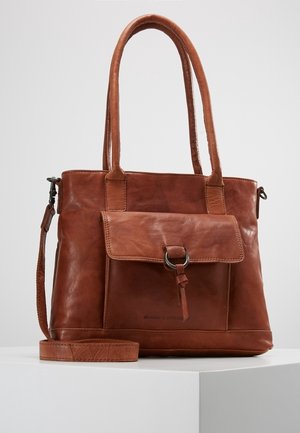 Brun læderhåndtaske med dobbelte håndtag, aftagelig rem, frontklap med metalringdetalje og glat tekstur.