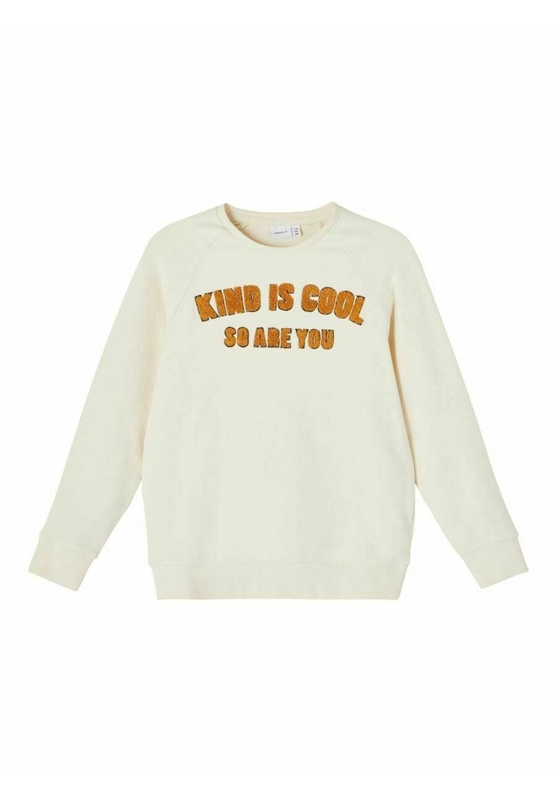 Cream-colored sweatshirt made of soft fabric, featuring raglan sleeves, rounded neck, and orange fuzzy text saying "KIND IS COOL SO ARE YOU."