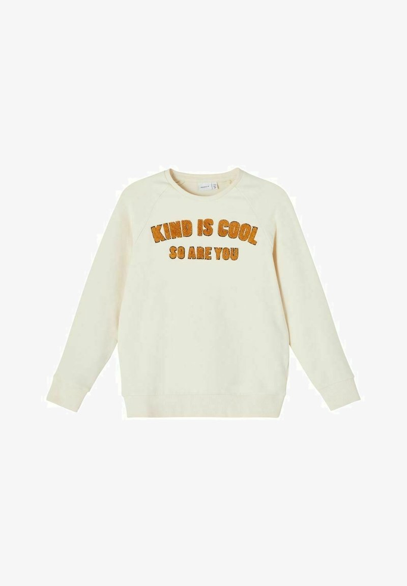 Cremefarbenes Sweatshirt aus weichem Material, mit Raglanärmeln, Rundhalsausschnitt und orangefarbigem, flauschigem Text, der sagt: "KIND IST COOL, DU BIST ES AUCH."