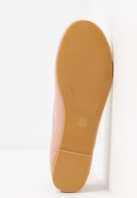 Semelle en suède rose avec surface texturée ; comporte une semelle extérieure en caoutchouc marron et la taille 37 marquée au bas.