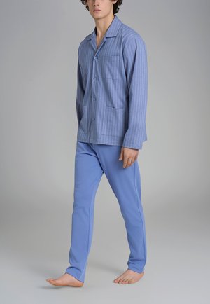 Maglietta da pigiama in cotone a righe blu con taschino sul petto, abbinata a pantaloni solidi di un blu chiaro. Tessuto morbidissimo, apertura con bottoni e vestibilità comoda.