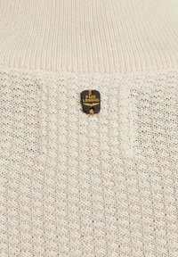 Crèmekleurige gebreide trui met een getextureerd patroon, voorzien van een PME Legend logo badge op de stof gestikt.
