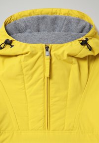 Gul vandtæt jakke med krave foret med gråt fleece, lynlås foran og justerbar hætte med snor. Synlige syninger og glat tekstur.