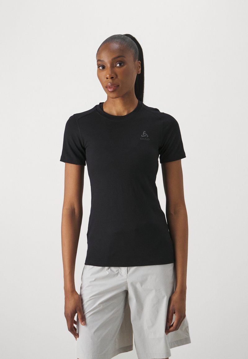 T-shirt de sport noir à manches courtes en tissu léger, avec un col rond et un logo discret sur la poitrine.