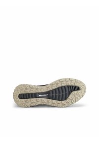 Sula av en sko med en robust, texturerad design i svart och beige färgschema, där Michelin-logotypen och mönsterna i sulan tydligt syns.