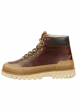 Brune læder høj-top støvle med gummisål, tekstureret tåhætte og blødt for. Messinghardware og kontrastfarvet beige sål med riller.