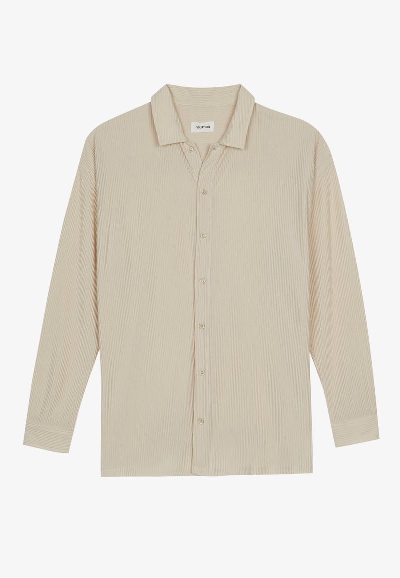 Maglietta beige a maniche lunghe con costine, colletto e bottoni frontali, distesa su uno sfondo bianco.