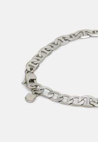 Collana in metallo argento con maglie intrecciate, un robusto moschettone e un piccolo tag con dettaglio del logo.