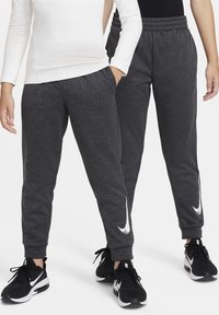 Grijze joggingbroek met elastische tailleband en taps toelopende benen, met een witte Nike-logo-accent op het onderbeen. Zachte, gestructureerde stof.