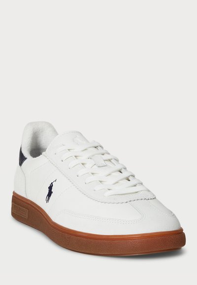 Λευκό σνίκερ με λείο δερμάτινο άνω μέρος, καουτσούκ σόλα και υφασμάτινες λεπτομέρειες. Περιλαμβάνει λευκές κορδόνες και ναυτικές λεπτομέρειες κοντά στη φτέρνα.