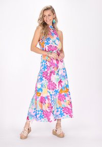 Rochie maxi florală colorată, cu motive roz, bleu și portocalie, design cu guler halter și fustă în straturi. Purtați cu sandale espadrile.