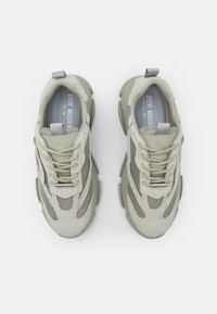 Sneaker grigio chiaro con tomaia in rete, dettagli in suede, linguetta imbottita, suola testurizzata e dettagli metallici sui lacci.