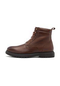 Botine negre din piele cu un finisaj texturat, vârful rotund și talpa din cauciuc negru. Prezintă ochiuri metalice și o curea de tragere pe spate.
