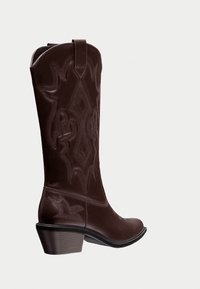 Brune læder cowboystøvler med intrikate broderimønstre, spidse tæer og en let hævet hæl. Har en trækflap øverst.