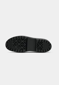 Talpa de cauciuc negru cu un model de profil geometric. Dispune de nervuri groase și o suprafață texturată pentru aderență și durabilitate.
