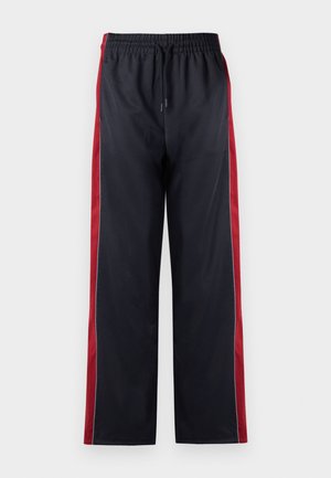 Pantalons de sport noirs avec des rayures latérales rouges, dotés d'une taille élastique et d'un cordon de serrage. Texture lisse, design à jambe droite, sans logos visibles.