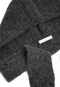 Tumehall, tekstuuriga sall, mis on valmistatud pehmest ja karedast kangast, millel on sujuv silt brändi nimega. Omab laia, ristkülikukujulist vormi.