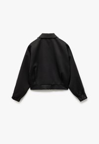 Chaqueta negra corta fabricada en tejido suave, con cuello, mangas largas con puños elásticos y franjas blancas a lo largo de las mangas.