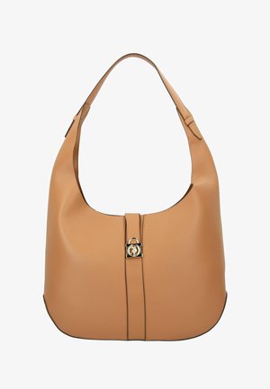 Handtas van lichtbruin leer met een gebogen vorm, voorzien van een brede, platte schouderband en een goudkleurig metalen detail bij de centrale sluiting.