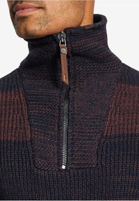 Maglione a mezze zip lavorato a maglia in blu scuro e bordeaux, con un motivo textured, colletto alto e una cerniera in metallo argentato con una linguetta in pelle.
