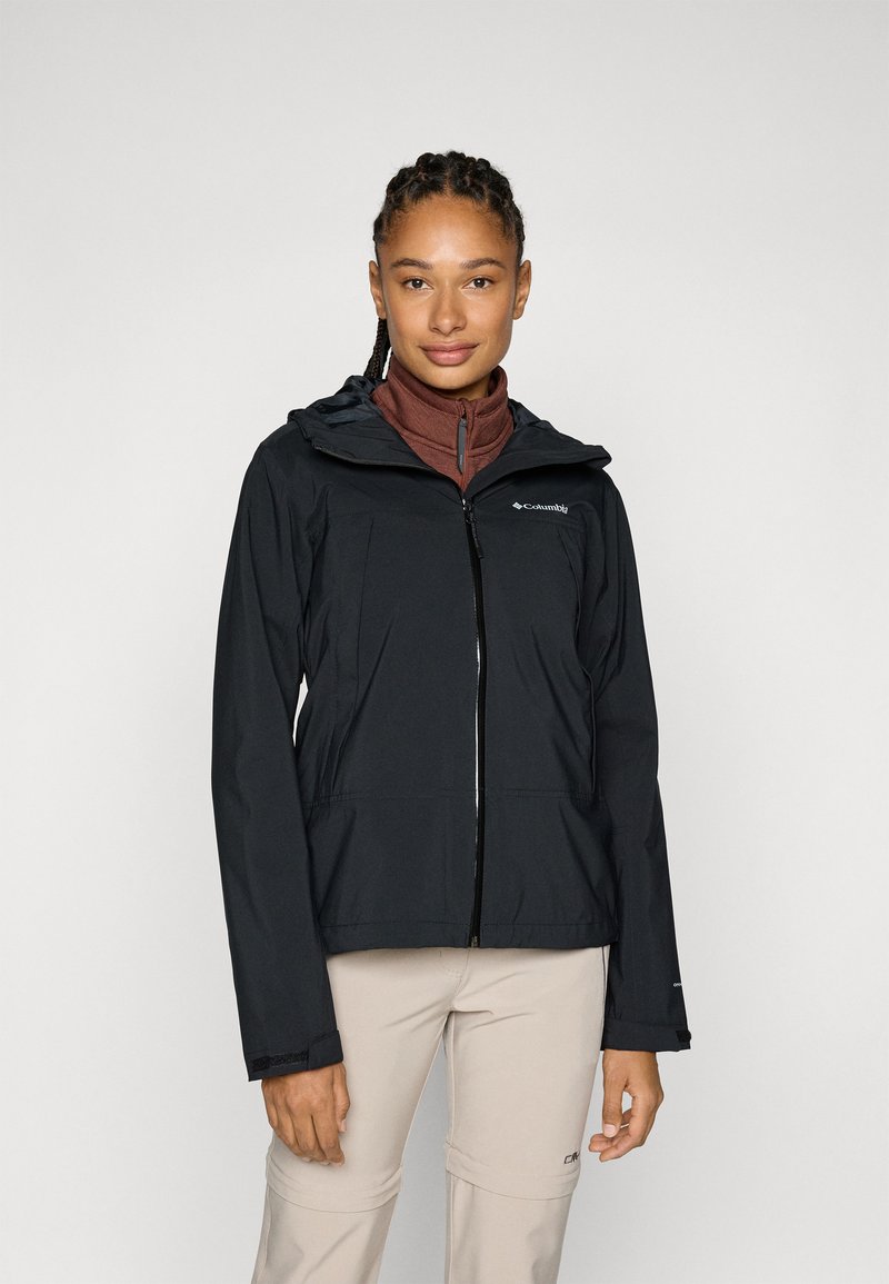 Black waterproof jacket with a front zipper, adjustable hood, and two pockets, worn over a brown high-neck top. Smooth texture, lightweight design.