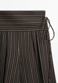 Dark brown skirt with thin white vertical pinstripes, pleats, and a wide waistband tied with a side bow.
