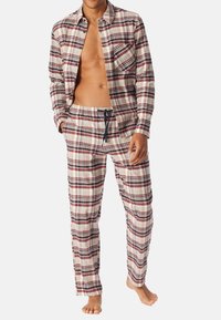 Pajama set z flaneli w kratę w odcieniach beżu, czerwieni i granatu. Koszula na guziki z jedną kieszenią na piersi oraz spodnie z elastycznym paskiem. Miękka tekstura, luźny krój.