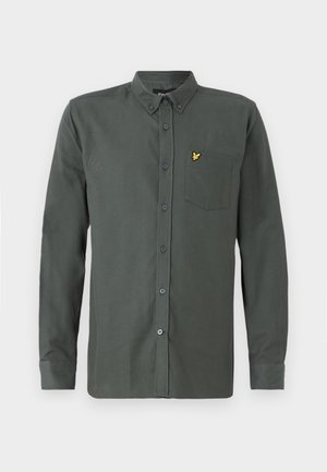 Dark green long-sleeve shirt made of cotton blend. Features button closure, collar, single chest pocket, and a small yellow logo on the pocket.