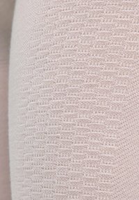 Tissu rose clair avec un motif texturé, comportant de petites lignes horizontales en relief et une apparence de maille fine. Matériau doux.