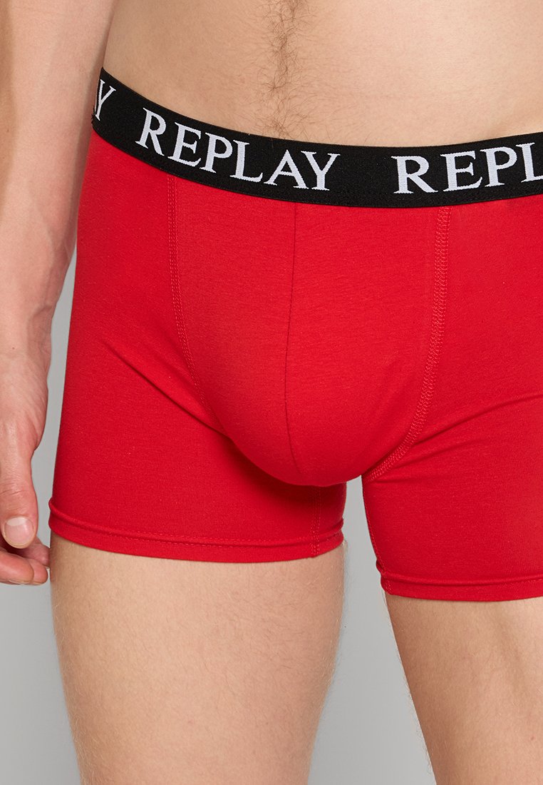Rote Baumwoll-Boxershorts mit einem schwarzen elastischen Bund, der mit weißem "REPLAY"-Text versehen ist. Glatte Textur und taillierte Passform.