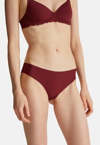 Bordeaux bh met kantafwerking en bijpassende naadloze bikini. Zachte stof, gladde textuur en klassieke snit met minimale bedekking aan de zijkanten.