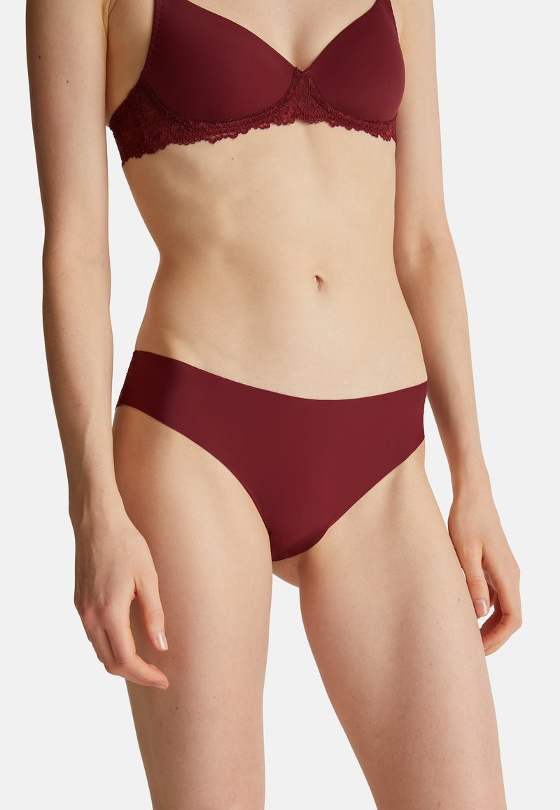 Bordeaux bh met kantafwerking en bijpassende naadloze bikini. Zachte stof, gladde textuur en klassieke snit met minimale bedekking aan de zijkanten.