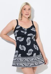 Vestido de baño negro con patrón floral blanco. Presenta tirantes ajustables, un cuerpo entallado y una falda acampanada con un dobladillo decorativo.