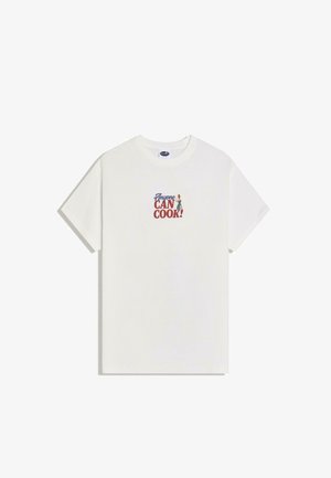 Maglietta bianca a maniche corte con la scritta "Chiunque PUÒ CUCINARE!" e una piccola illustrazione di uno chef che tiene un cucchiaio di legno sul petto.