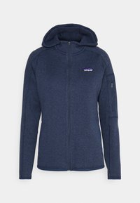 Marineblå fleece hettejakke med glidelås foran og sidelommer. Har et logo-patch på brystet og teksturert stoff.