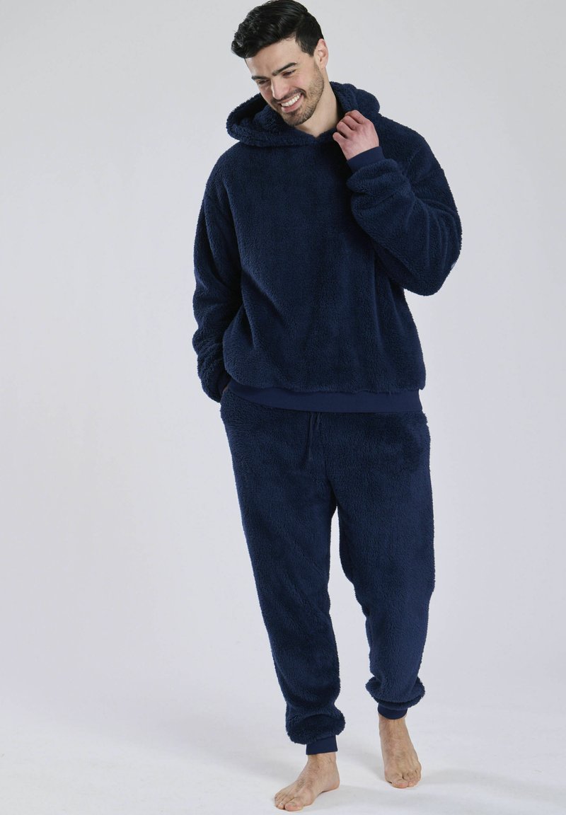 Navyblauw fleece loungewearset met een hoodie met een zachte textuur, een ontspannen pasvorm en bijpassende broek met elastische manchetten.