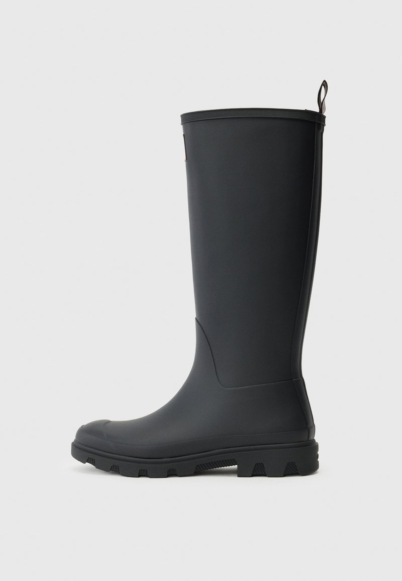 Black rubber rain boot with a smooth surface, rounded toe, and textured sole. Features a small pull tab on the top for easy wear.