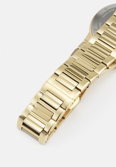 Bracciale in metallo dorato con maglie rettangolari aventi una finitura spazzolata. Dettaglio inciso "FERRAGAMO" su un link. Design complessivo elegante.