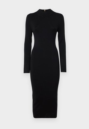 Robe noire ajustée à manches longues, col haut, texture côtelée et silhouette mi-longue. Comprend une fermeture éclair au dos avec des accessoires en or.