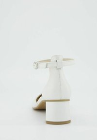 Valge kontsaga sandaal, millel on pöidla rihm, plokk-konts, sile nahktextuur, avatud varvaste disain ja ümar tagaosa. Lihtne õmbluse detail.