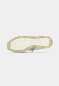 Αθλητικό παπούτσι με υφή γκρι σουέντ επάνω μέρος, λευκή λαστιχένια σόλα και σχεδιασμό πέλματος με μοτίβο. Διαθέτει ενισχυμένη φτέρνα για υποστήριξη.