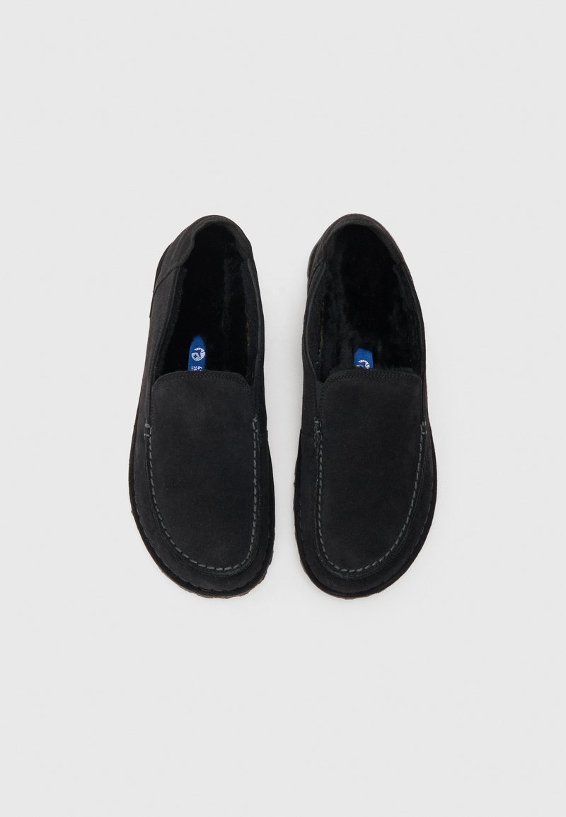 Zapatos negros tipo mocasín con un suave upper de ante texturizado, un interior acolchado, y costuras en contraste en la suela.